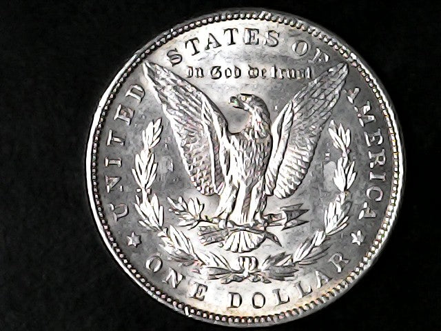Silver Dollar with an eagle design and 'In God We Trust' inscription on a black background