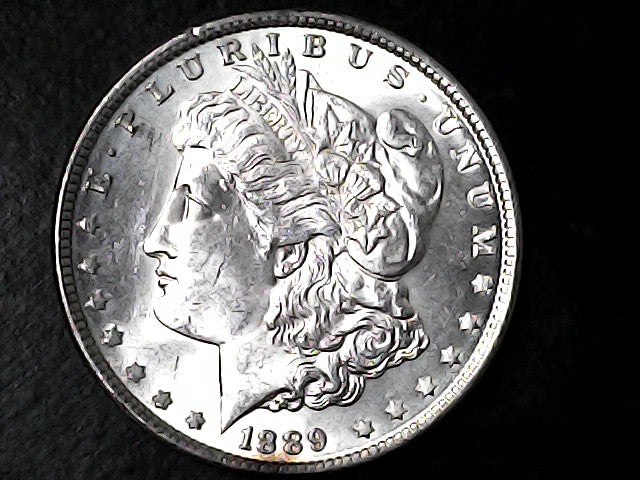 Silver Morgan Dollar with 'E Pluribus Unum', 'Liberty'  and '1889' inscriptions on a black background