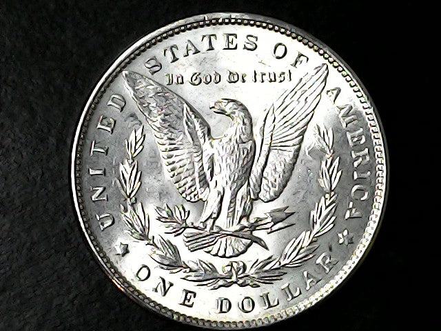 Silver Silver dollar coin with an eagle design on a black background 