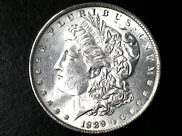 Silver Morgan Dollar with 'E Pluribus Unum', 'Liberty'  and '1889' inscriptions on a black background