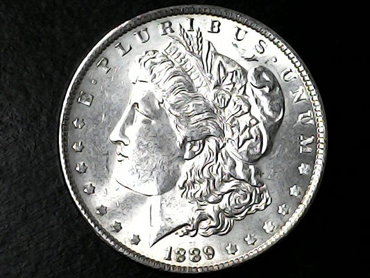 Silver Morgan Dollar with 'E Pluribus Unum', 'Liberty'  and '1889' inscriptions on a black background