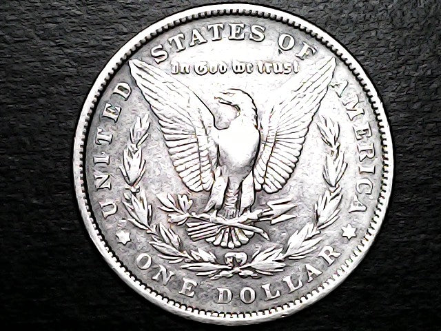Silver Dollar with an eagle design and 'In God We Trust' on a black background