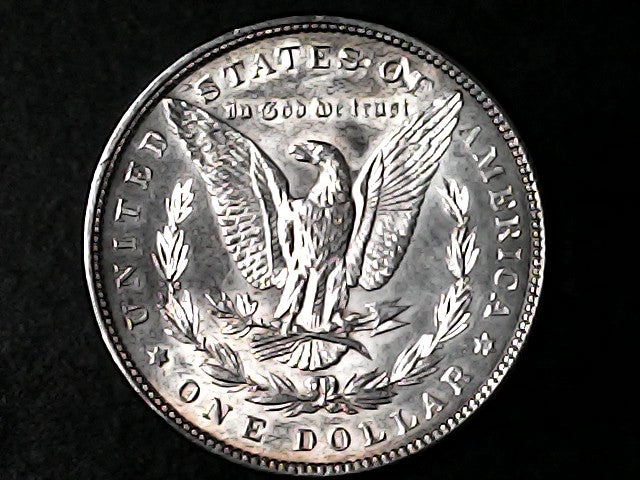 Silver Dollar with an eagle design and 'In God We Trust' inscription on a black background