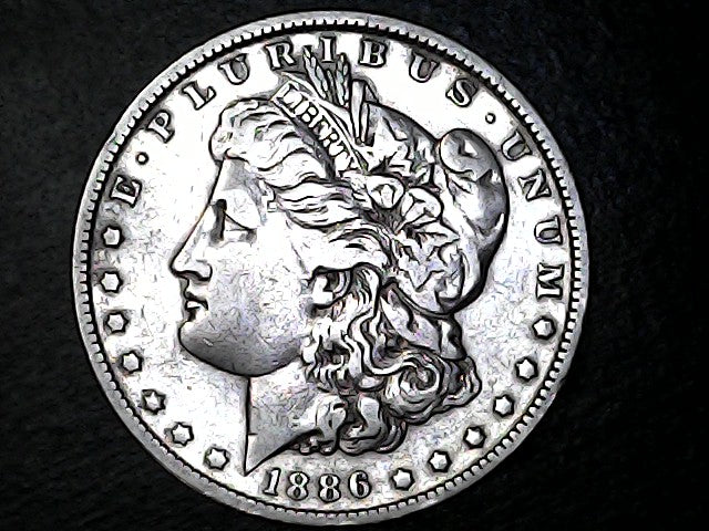 Silver Morgan Dollar Left-facing profile of Liberty wearing a Phrygian cap, with 'LIBERTY', "E PLURIBUS UNUM" and '1886' inscriptions on a black background with case