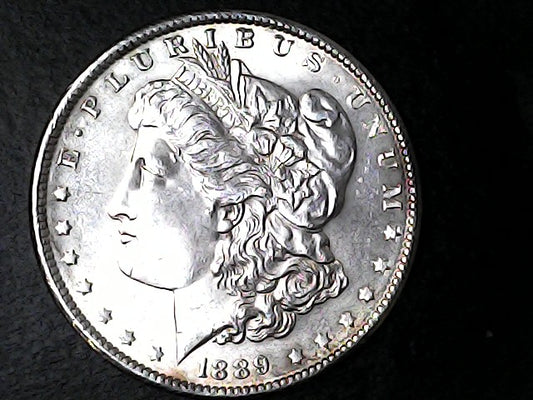 Silver Morgan Dollar with 'E Pluribus Unum', 'Liberty'  and '1889' inscriptions on a black background