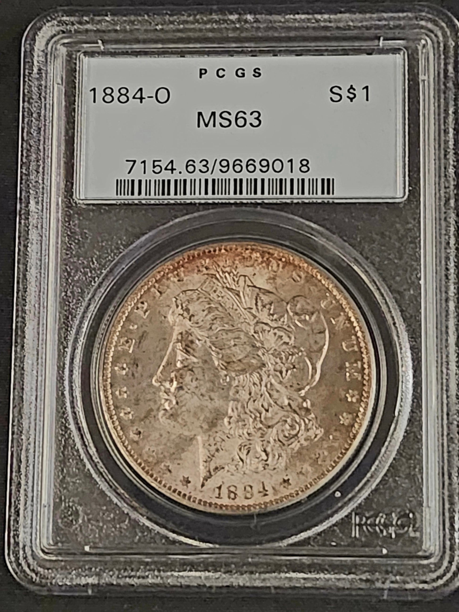 Morgan silver dollar coin in a protective holder with PCGS grading label