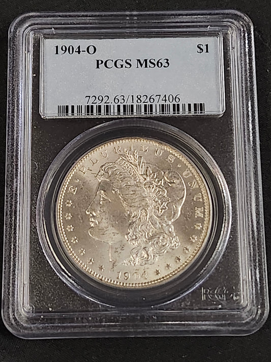 194-O Morgan silver dollar in a protective case with PCGS MS63 label on a black background bar code 7292.63/18267406