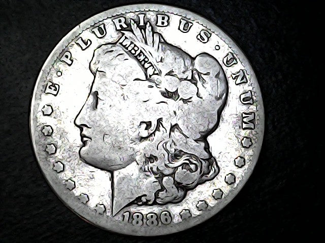Silver Morgan Dollar Left-facing profile of Liberty wearing a Phrygian cap, with 'LIBERTY', "E PLURIBUS UNUM" and '1886' inscriptions on a black background with case