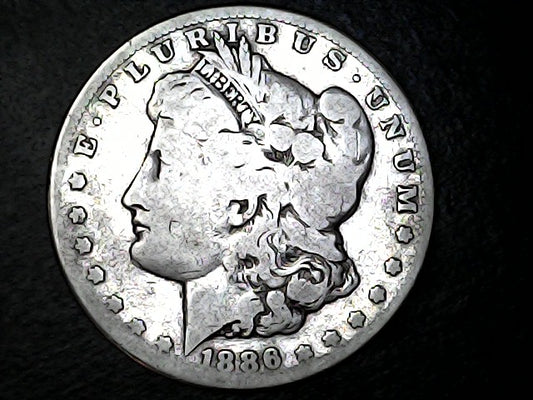 Silver Morgan Dollar Left-facing profile of Liberty wearing a Phrygian cap, with 'LIBERTY', "E PLURIBUS UNUM" and '1886' inscriptions on a black background with case