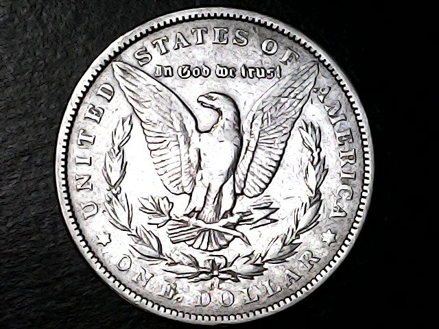 Silver Dollar with an eagle design with "CC" inscription on a black background
