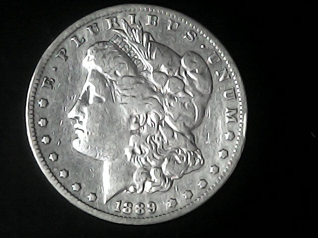 Silver Morgan Dollar with 'E Pluribus Unum', 'Liberty'  and '1889' inscriptions on a black background with case