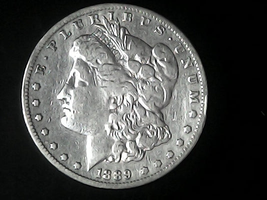Silver Morgan Dollar with 'E Pluribus Unum', 'Liberty'  and '1889' inscriptions on a black background with case
