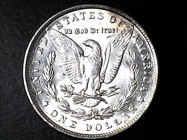 Silver dollar coin with an eagle design on a black background