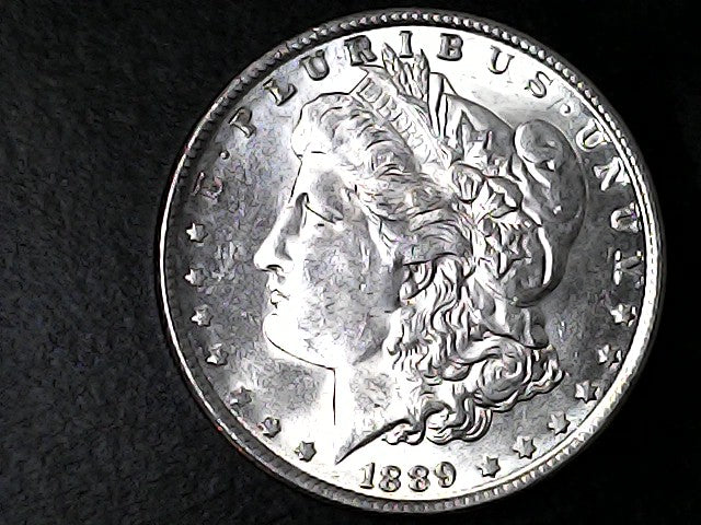 Silver Morgan Dollar with 'E Pluribus Unum', 'Liberty'  and '1889' inscriptions on a black background