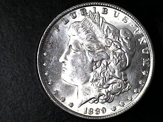 Silver Morgan Dollar with 'E Pluribus Unum', 'Liberty'  and '1889' inscriptions on a black background