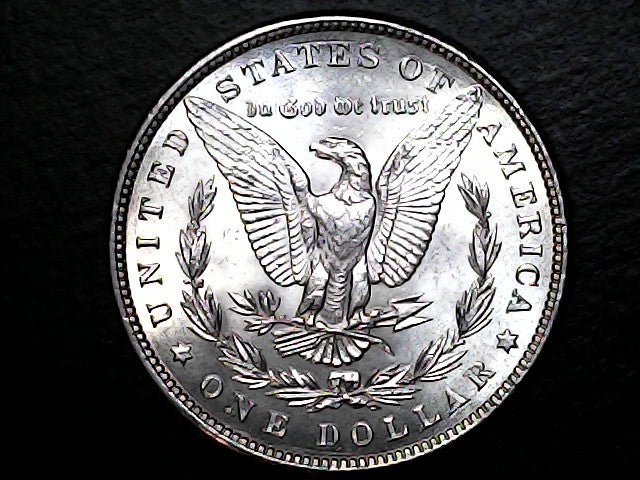 Silver dollar coin with an eagle emblem on a black background