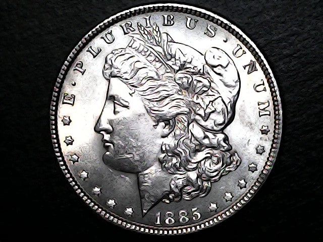 Silver Morgan dollar coin with profile of Liberty on a black background