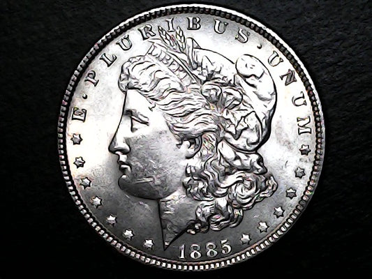 Silver Morgan dollar coin with profile of Liberty on a black background