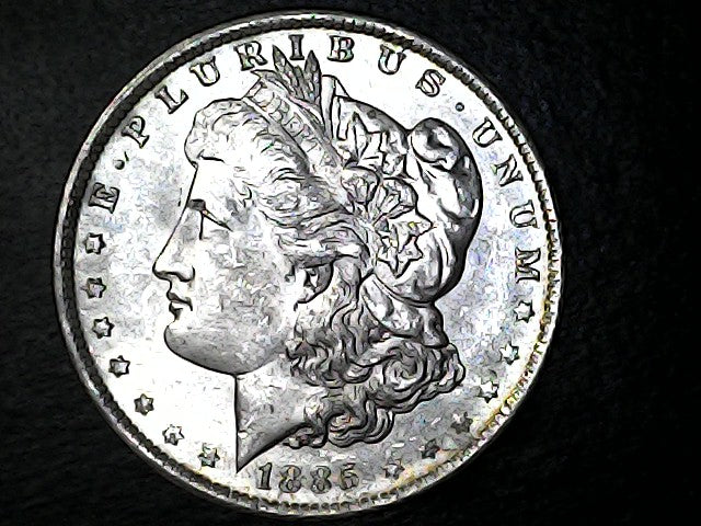 Silver Morgan dollar coin with 'E Pluribus Unum' inscription on a dark background