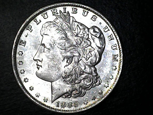 Silver Morgan dollar coin with 'E Pluribus Unum' inscription on a dark background