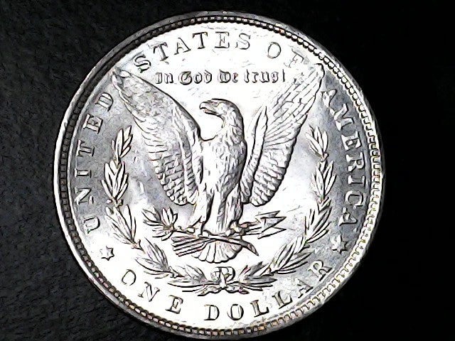 Silver Dollar coin with an eagle design on a black background 