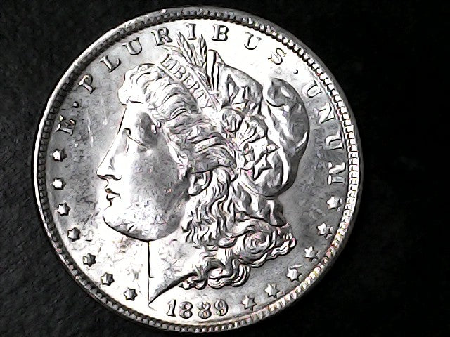 Silver Morgan Dollar with 'E Pluribus Unum', 'Liberty' and '1889' inscriptions on a black background