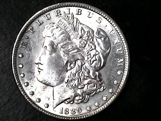 Silver Morgan Dollar with 'E Pluribus Unum', 'Liberty' and '1889' inscriptions on a black background