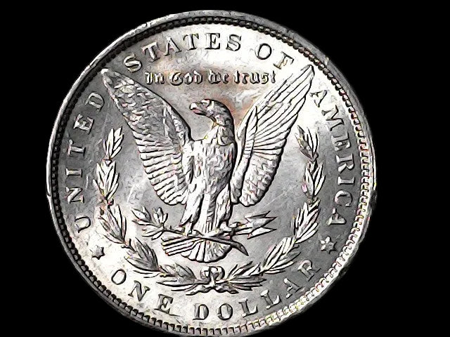 Silver Dollar with an eagle design and 'In God We Trust' inscription on a black background