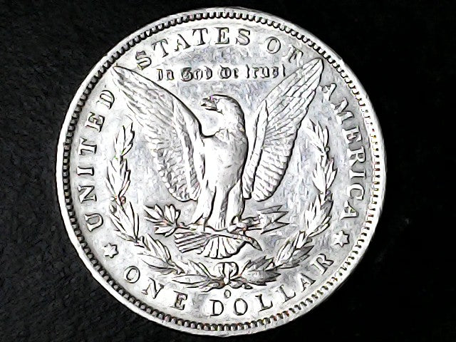 Silver Dollar with an eagle design, 'In God We Trust' and 'O' inscriptions on a black background 