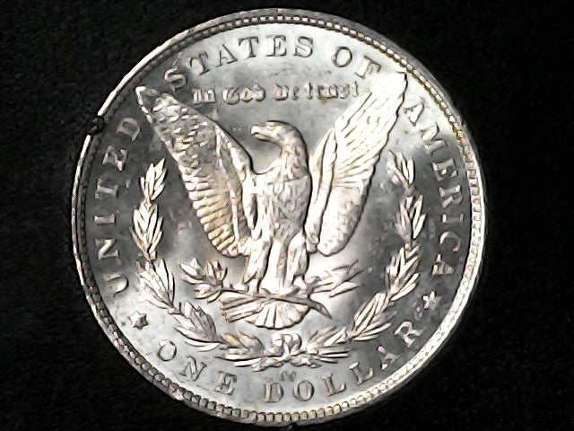 Silver Dollar with an eagle design, 'In God We Trust' and "CC" inscription on a black background