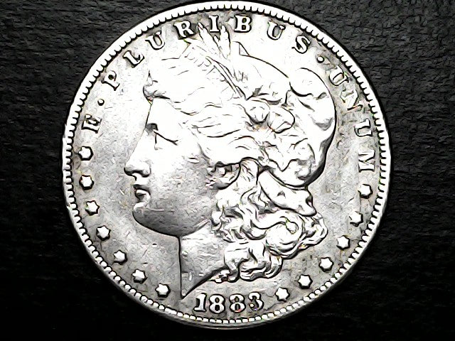 Silver Morgan dollar coin with a dark background