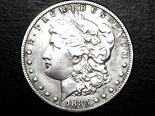 Silver Morgan dollar coin with a dark background