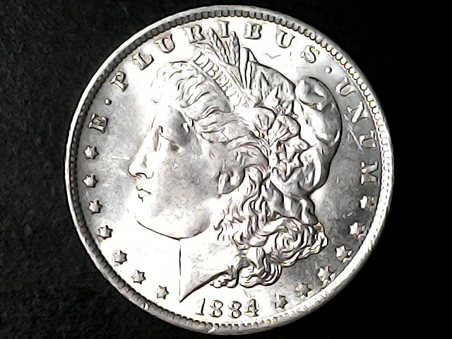 Silver Morgan dollar coin with 'E Pluribus Unum' and '1884' on a black background