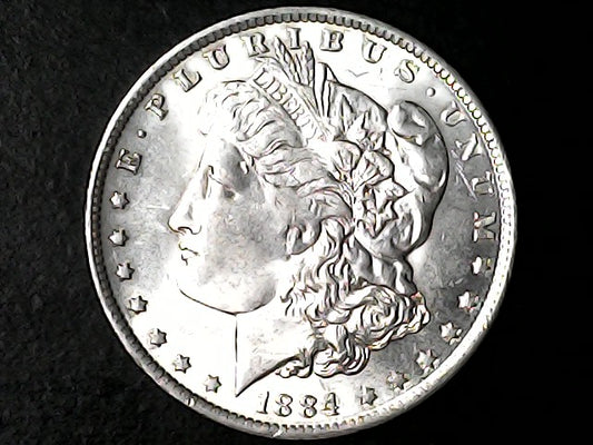 Silver Morgan dollar coin with 'E Pluribus Unum' and '1884' on a black background