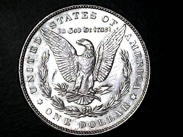 Silver dollar coin with an eagle design on a black background