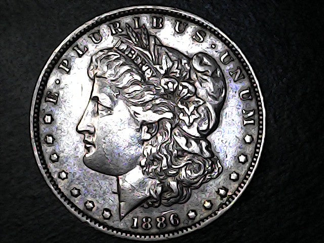 Silver Morgan dollar coin with Libertas head on a dark background