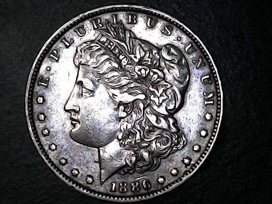 Silver Morgan dollar coin with Libertas head on a dark background
