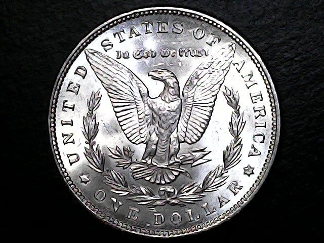 Silver Morgan dollar with an eagle design on a black background