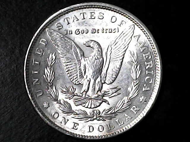 Silver Dollar coin with an eagle design on a black background 