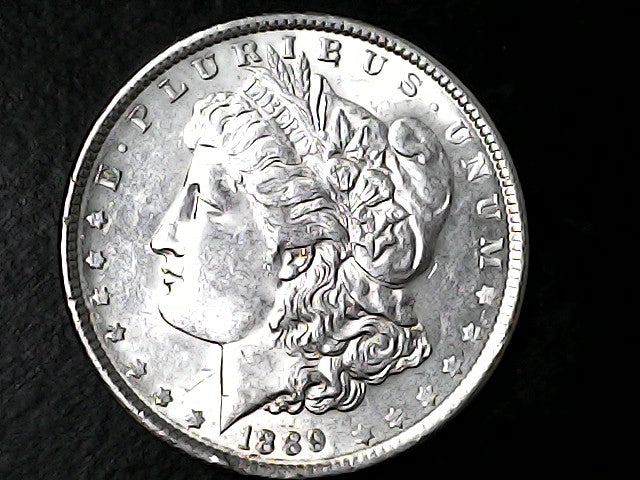 Silver Morgan Dollar with 'E Pluribus Unum', 'Liberty'  and '1889' inscriptions on a black background
