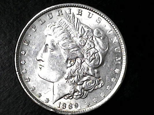 Silver Morgan Dollar with 'E Pluribus Unum', 'Liberty'  and '1889' inscriptions on a black background