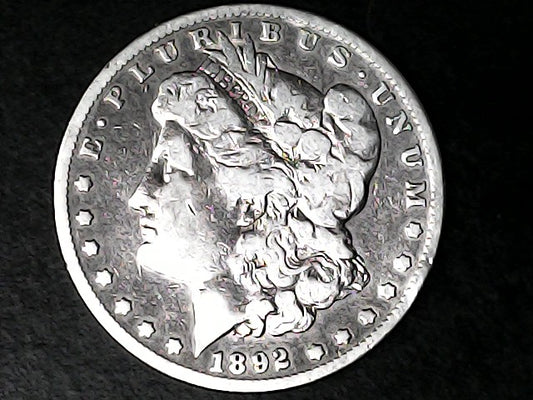 Silver Morgan Dollar Left-facing profile of Liberty wearing a Phrygian cap, with 'LIBERTY', "E PLURIBUS UNUM" and '1892' inscriptions on a black background with case