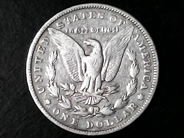 Silver Dollar with an eagle design and 'In God We Trust' inscription on a black background