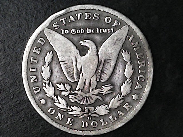 Silver Dollar with an eagle design, 'In God We Trust' and 'O' inscriptions on a black background 