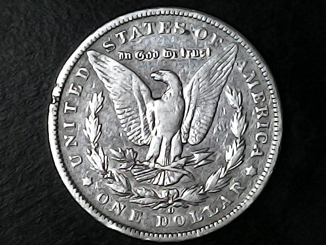 Silver dollar coin with an eagle emblem and 'O' on a dark background