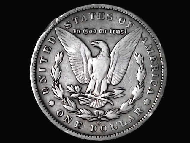 Silver Dollar with an eagle design, 'In God We Trust' and 'O' inscriptions on a black background 