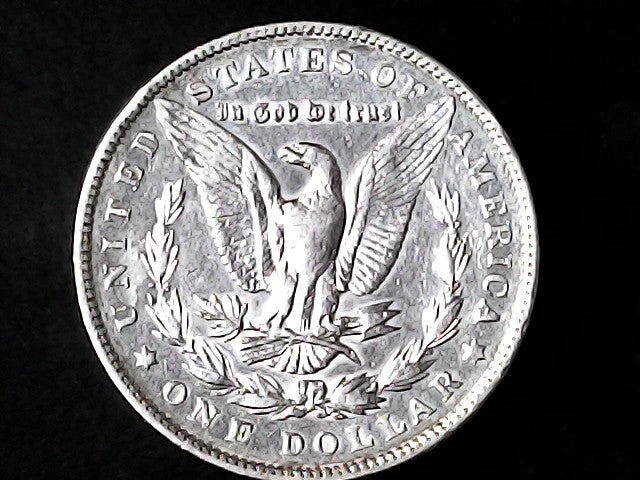 Silver Dollar with an eagle design and 'In God We Trust' inscription on a black background