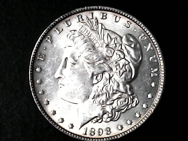Silver Morgan Dollar Left-facing profile of Liberty wearing a Phrygian cap, with 'LIBERTY', "E PLURIBUS UNUM" and '1898' inscriptions on a black background with case