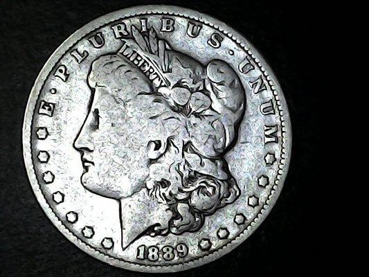 Silver Morgan Dollar with 'E Pluribus Unum', 'Liberty'  and '1889' inscriptions on a black background 
