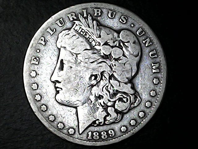 Silver Morgan Dollar with 'E Pluribus Unum', 'Liberty'  and '1889' inscriptions on a black background